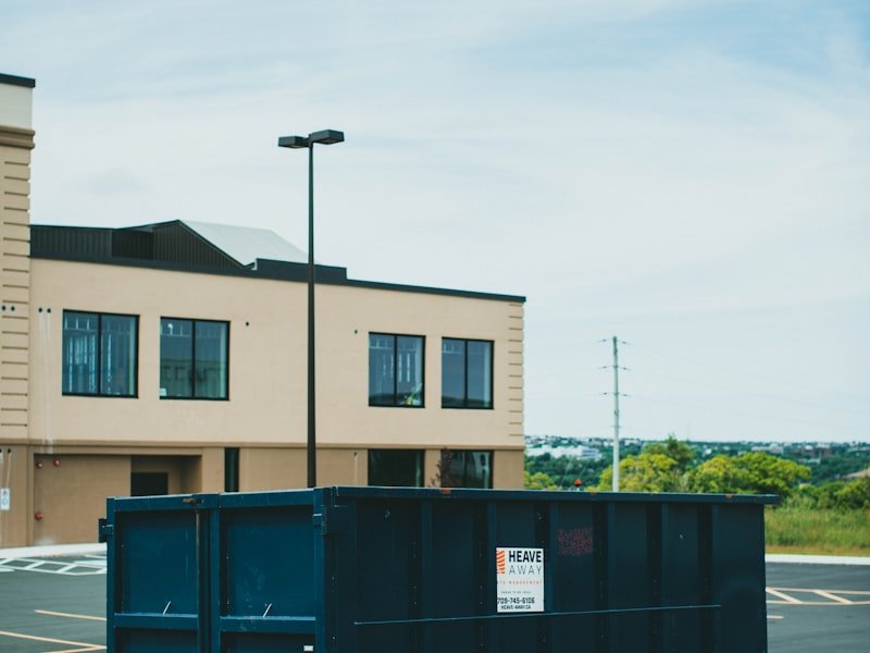 Blue 20-yard roll-off dumpster placed in a commercial parking lot